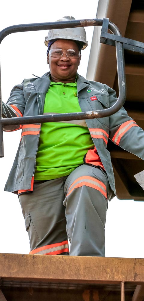African woman climbing into construction vehicle